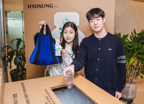 효성티앤씨 직원들이 페트병 수거함 앞에서 리젠 적용 가방과 재활용할 페트병을 들고 있다. / 사진제공:효성티앤씨