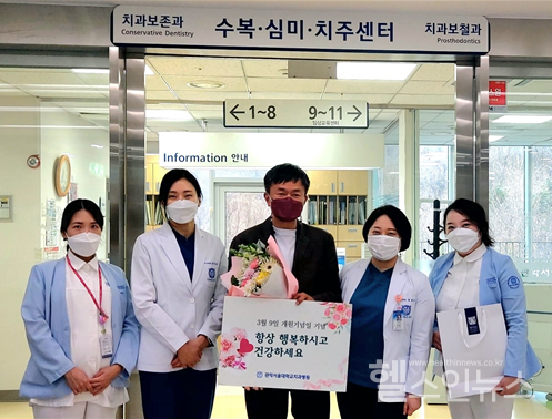 관악서울대학교치과병원교직원이개원8주년을맞아내원환자에게꽃다발과기념품을전달하고있다.