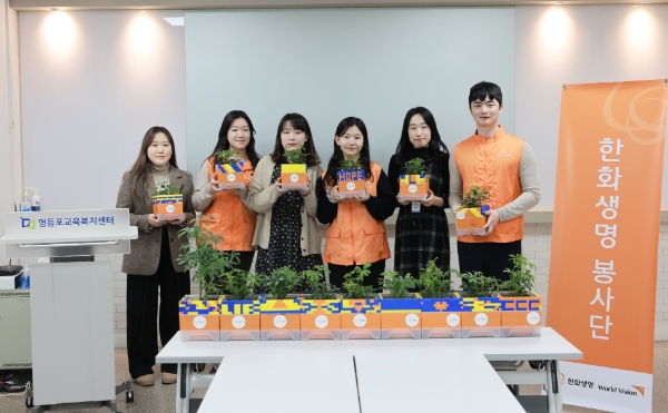 한화생명 임직원 봉사단이 만든 공기정화식물 화분을 영등포 교육복지센터에 전달했다. 한화생명 직원과 영등포 교육복지센터 직원이 함께 화분을 들고 환하게 웃고 있다. / 사진제공:한화생명