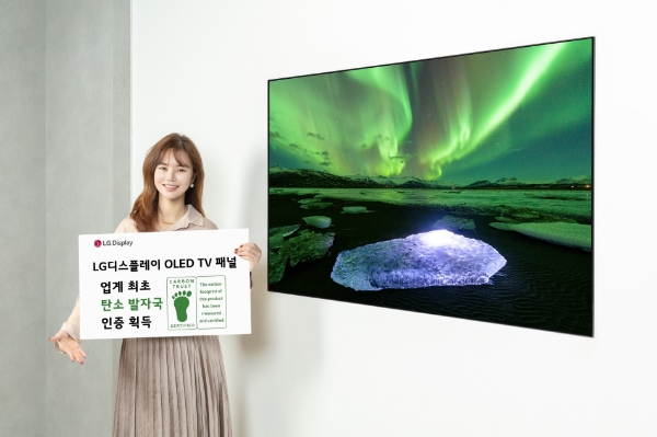 LG디스플레이 OLED TV 패널이 디스플레이 업계 최초로 카본 트러스트 탄소발자국 인증을 획득했다. 사진은 LG디스플레이 모델이 카본 트러스트 인증서와 OLED TV 패널을 소개하는 모습. / 사진제공:LG디스플레이