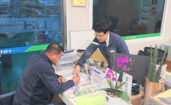 지난 23일 경북 성주 초전농협 자재판매장을 찾은 한 농업인이 농협 필름 담당자의 설명을 들으며 하우스필름 예약구매 신청서를 작성하고 있다. / 제공:농협