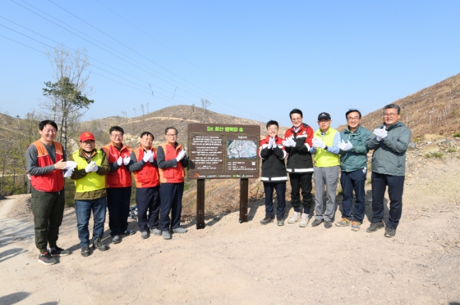 참석자들이 ‘SK 울산 행복의 숲’ 현판 앞에서 기념사진을 촬영하고 있다. (왼쪽 다섯 번째부터 유재영 SK이노베이션 울산CLX 총괄 부사장, 서정욱 울산광역시 행정부시장, 이순걸 울주군수 등) / 사진 = SK이노베이션 제공