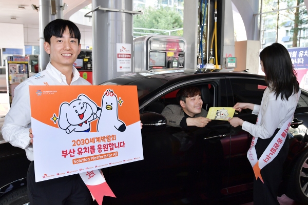 SK에너지 구성원들이 주유고객에게 부산엑스포 유치 기원 차량부착용 스티커를 배포하고 있다. / 제공:SK에너지