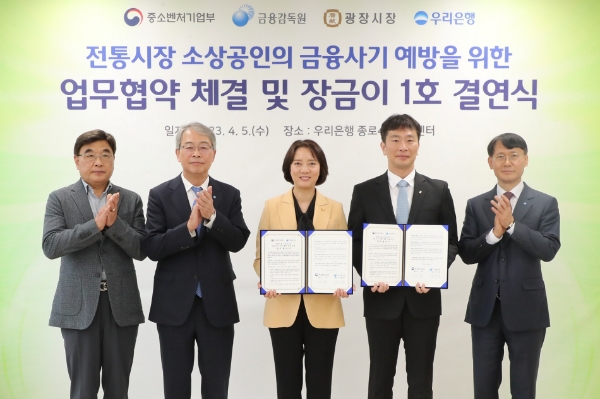 우리은행(은행장 이원덕)이 5일 광장시장 인근 소재 종로4가금융센터에서 광장시장과 ‘장금이 1호 결연’을 맺었다. 왼쪽부터 김영재 광장시장 상인총연합회 회장, 임종룡 우리금융그룹 회장, 이영 중소벤처기업부 장관, 이복현 금융감독원장, 정연기 우리은행 중소기업그룹 부행장이 기념촬영을 하고 있다. / 제공:우리금융그룹