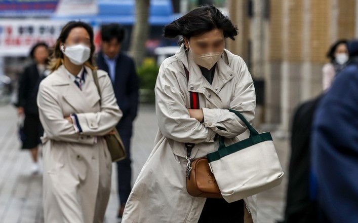 비가 내린 뒤 쌀쌀한 날씨를 보인 지난 6일 오전 서울 종로구 광화문광장 인근에서 시민들이 몸을 웅크린 채 이동하고 있다.