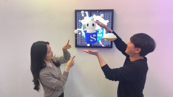 디지로그브랜치 서소문에서 증강 현실(AR)로 ‘피어리’와 기념촬영하는 모습. / 제공:신한은행