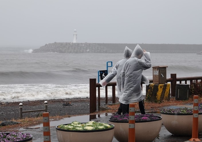 제주 서귀포시 남원읍 해안가에서 관광객들이 비 오는 거리를 걷고 있다.