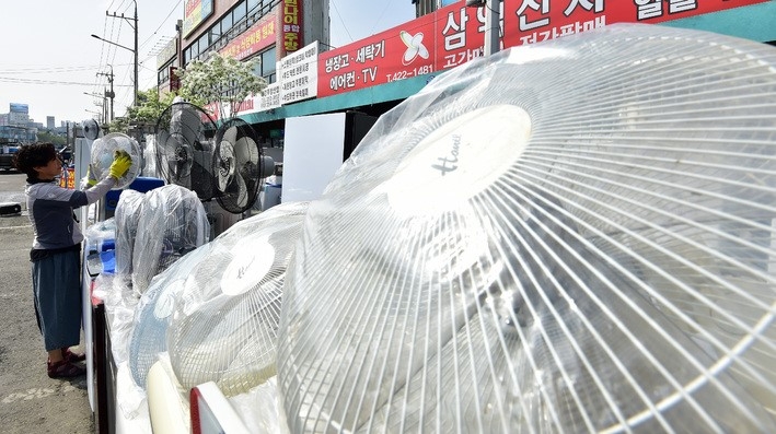 초여름 날씨를 보인 지난 19일 대구 북구 칠성시장 중고 가전제품 상점에서 한 상인이 선풍기의 묵은 먼지를 닦아내고 있다.