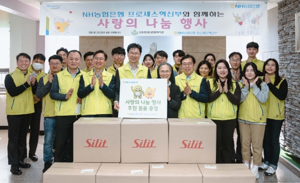 강태영 부행장(푯말 든 왼쪽)과 프로세스혁신부 임직원들이 후원 물품 전달 후 기념사진을 촬영하고 있다. / 제공:NH농협은행