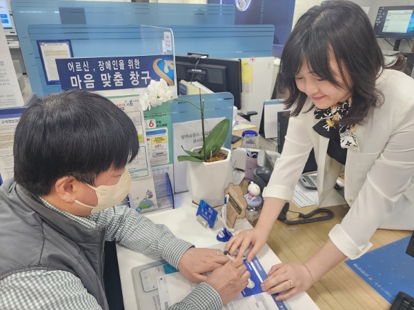 20일 서울 소재 신한은행 영업점에서 직원이 ‘마음맞춤 응대 KIT’를 활용해 시각장애인 고객과 업무하는 모습. / 제공:신한은행