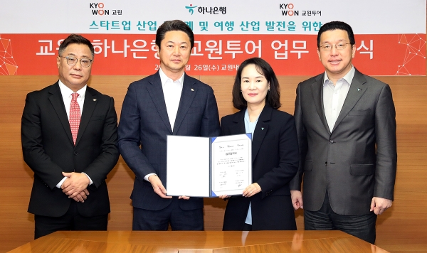 하나은행은 지난 26일 오후 서울 중구 교원그룹 본사에서 교원그룹과 스타트업 생태계 활성화 지원을 위한 업무 협력 및 여행과 금융의 융합 비즈니스 공동 추진을 위한 전략적 업무협약(MOU)을 체결했다고 밝혔다. 김소정 하나은행 디지털그룹장(사진 왼쪽에서 세번째), 황보현우 하나은행 데이터&제휴투자본부장(사진 왼쪽에서 네번째), 신영욱 교원 대표이사(사진 왼쪽에서 두번째), 김명진 교원투어 사업대표(사진 왼쪽에서 첫번째)가 기념촬영을 하고 있다. / 제공:하나은행