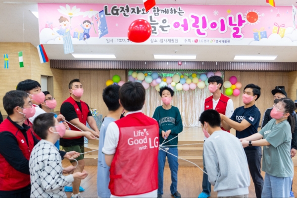 LG전자는 어린이날을 맞아 4일 서울 암사재활원에 거주하는 장애 아동·청소년들을 위해 <오늘은 어린이날> 행사를 가졌다. 사진은 암사재활원 강당에서 LG전자 직원들과 장애아동들이 협동 공던지기를 하는 모습. / 제공:LG전자