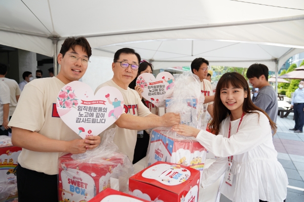 롯데건설 박현철 대표이사 부회장(왼쪽에서 두번째)이 5월 가정의 달을 맞아 서울 서초구 잠원동에 위치한 롯데건설 본사에서 직원들에게 과자 선물세트와 카네이션을 전달하고 있다. / 제공:롯데건설