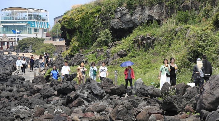 비교적 맑은 날씨를 보인 11일 오후 제주시 애월읍 한담해변을 찾은 관광객들이 절벽 아래를 따라 놓인 산책길을 걸으며 즐거운 시간을 보내고 있다.