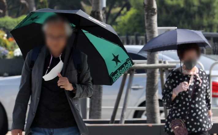 서울 낮 최고기온이 30도를 넘는 초여름 날씨를 보인 지난 16일 오후 서울 송파구 거리에서 시민들이 양산을 들고 이동하고 있다.