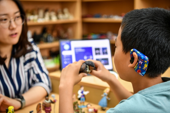 한 아동이 신규 디자인 엠브레인을 착용하고 상담사와 함께 심리 상담을 진행하고 있다. 상담사는 뇌파로 드러나는 아이의 스트레스, 불안 등 심리 상태를 모니터링해 효과적으로 상담을 진행할 수 있다. / 사진 = 현대모비스 제공