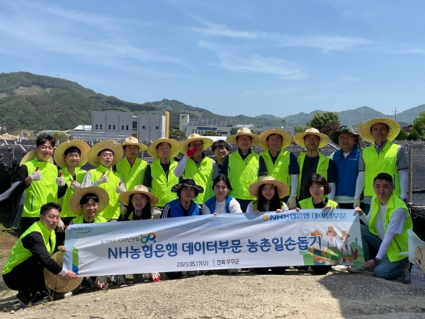 농협은행 데이터부문 임직원들이 전라북도 무주군 인삼 농가를 찾아 일손돕기 후 기념촬영을 실시하고 있다. / 사진=NH농협은행 제공