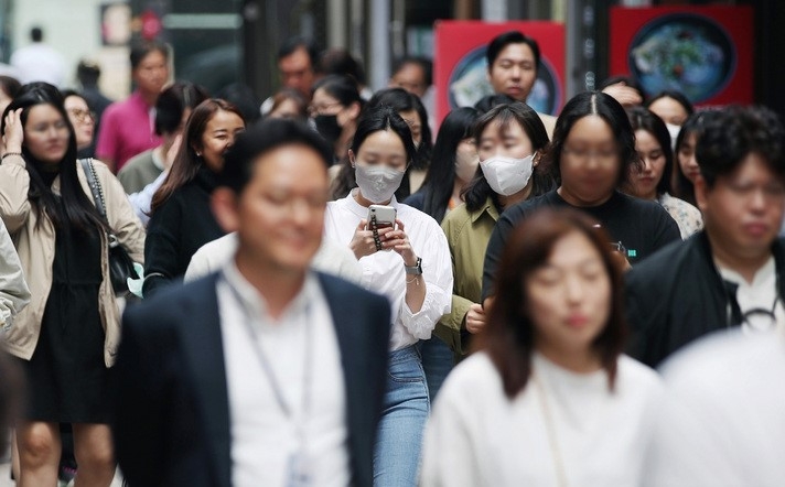 정부가 코로나19 위기 경보를 '심각'에서 '경계'로 하향하겠다고 밝혀 사실상 '엔데믹(endemic·풍토병으로 굳어진 감염병)'을 선언한 다음 날인 지난 12일 서울 중구 명동에서 마스크를 쓰거나 쓰지 않은 시민들이 발걸음을 옮기고 있다.