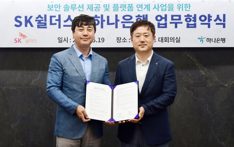 하나은행은 라이프 케어 플랫폼 기업 SK쉴더스와 지난 19일 서울 강남구 삼성동 소재 SK쉴더스 사옥에서 『보안솔루션 제공 및 금융서비스와 연계한 공동 비즈니스 추진』을 위한 업무협약을 체결했다. 협약식에 참석한 이동현 하나은행 기업사업본부장(사진 오른쪽)과 김윤호 SK쉴더스 성장추진실장이 기념촬영을 하고 있다. / 사진=하나은행 제공
