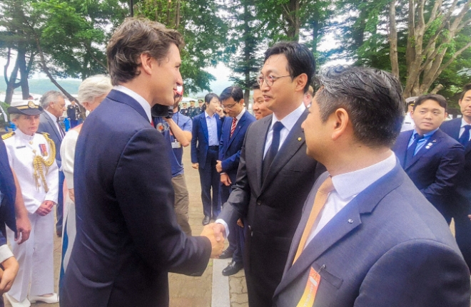지난 18일 경기도 가평군 참전비 경내에서 열린 ‘캐나다 참전 가평전투지 숲길 조성’ 기념식에서 쥐스탱 트뤼도 캐나다 총리와 이동훈 아워홈 부사장(가운데)이 인사를 나누고 있다. / 사진=아워홈 제공