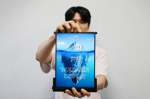 삼성디스플레이 직원이 SID 디스플레이 위크 2023에서 선보인 '롤러블 플렉스'를 펼쳐 보이고 있다. / 사진=삼성디스플레이 제공