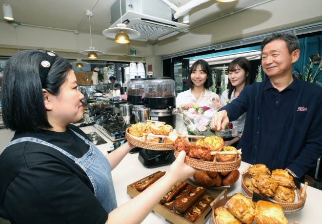 LG유플러스 황현식 대표가 25일 오전 'U+우리동네멤버십-용산 한강대로편'에 참여한 카페 롱브르378에서 영락보린원 원아들에게 전달할 빵을 고르고 있는 모습. / 사진=LG유플러스 제공