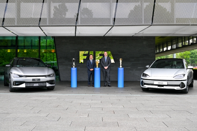 현대자동차그룹 기획조정실장 김걸 사장(왼쪽)과 지안니 인판티노(Gianni Infantino) FIFA 회장(오른쪽)이 조인식 이후 아이오닉 6, EV6 옆에서 기념 촬영을 하는 모습.