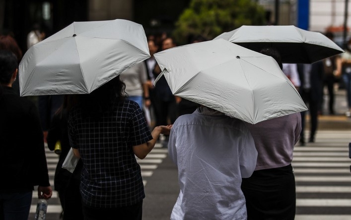 서울 낮 최고 기온이 27도까지 오르면서 초여름 날씨를 보일 것으로 예보된 지난 24일 서울 영등포구 여의도역 인근에서 양산을 쓴 시민들이 이동하고 있다.