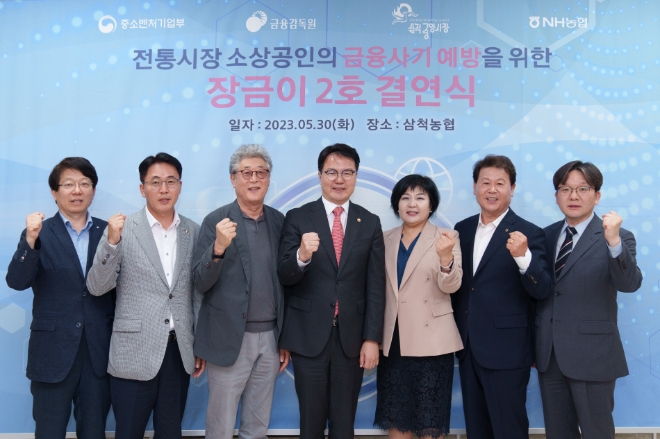 (사진 왼쪽부터) 윤종욱 중소벤처기업부 지청장, 이석용 NH농협은행장, 정종광 삼척중앙시장 상인회장,조주현 중소벤처기업부 차관,김미영 금융소비자보호처장, 이규정 삼척농협 조합장, 엄일용 금융감독원 지원장이 기념촬영하고 있다. / 사진=NH농협은행 제공