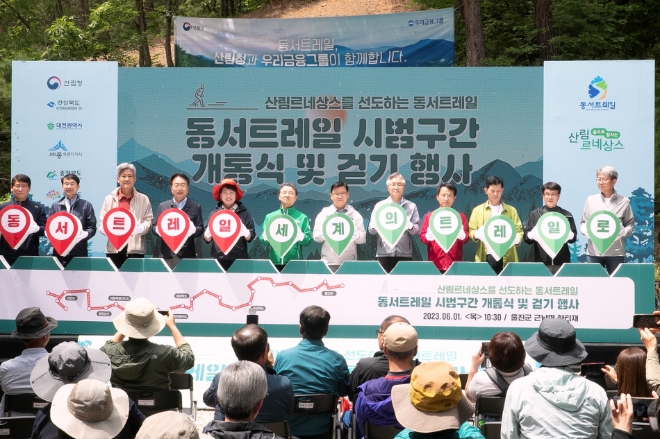 우리금융그룹(회장 임종룡)과 우리금융미래재단은 한반도의 동쪽과 서쪽을 연결하는 '동서트레일' 시범구간인 '우리금융길' 개통식을 가졌다. 손병복 울진군수(왼쪽에서 네번째), 이달희 경상북도 경제부지사(왼쪽에서 다섯번째), 남성현 산림청장(왼쪽에서 여섯번째), 이원덕 우리은행장(왼쪽에서 일곱번째), 전범권 한국등산트레킹센터이사장(왼쪽에서 여덟번째)과 관계자들이 기념촬영을 하고 있다. / 사진=우리금융 제공