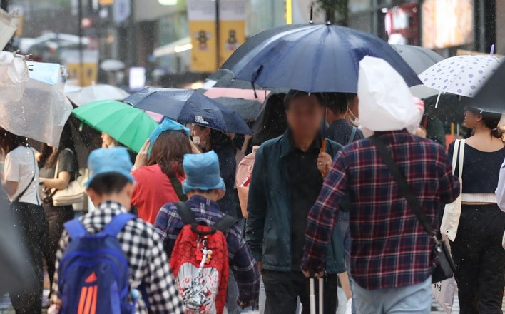  전국에 비가 내리고 있는 지난 5월 5일 오후 서울 중구 명동거리에서 관광객들이 머리에 비닐을 쓰고 이동하고 있다.