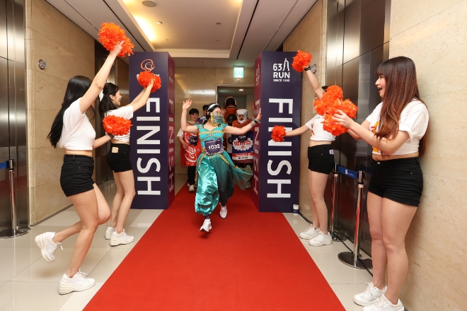 한화생명이 3일 63빌딩의 249m, 1,251개의 계단을 오르는 국내 최초의 수직 마라톤 행사 '2023 한화생명 시그니처 63 RUN'을 개최했다. 이번 행사는 기록·코스튬(이색복장)·크루(단체) 총 3개 부문으로 진행됐다. 사진은 이색복장 부문 참가자가 완주하며 환호성을 지르고 있는 모습. / 사진 = 한화생명 제공