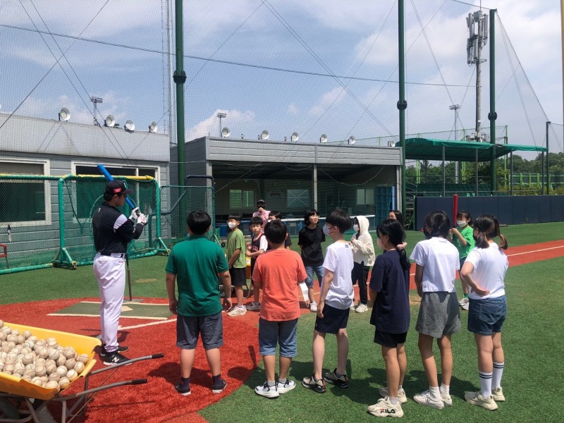 야구 체험 프로그램에 참가한 학생들이 티 배팅을 설명하는 코치의 설명을 진지하게 듣고 있다.[사진 kt위즈]