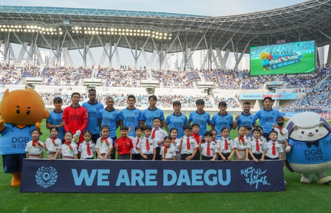티웨이항공은 지난 10일 DGB대구은행파크에서 수원FC를 상대로 열린 대구FC 홈 경기에서 ‘티웨이항공 브랜드데이’를 개최했다고 13일 밝혔다. 사진은 지난 10일 대구FC 홈 경기에서 진행한 ‘티웨이항공 브랜드데이’에서 티웨이항공 유니폼을 입은 에스코트 키즈 서포터즈들이 선수들과 함께 기념 촬영하는 모습. (사진 = 티웨이 항공 제공)