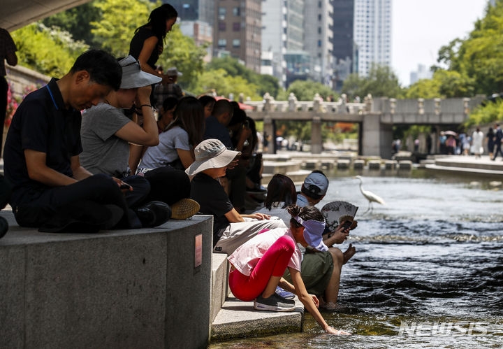 지난 19일 서울 중구 청계천에서 시민들이 햇빛을 피해 휴식을 취하고 있다.