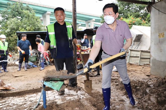 이상일 용인특례시장이 지난해 집중호우로 큰 피해를 입은 고기교 수해현장에서 직접 삽을 들고 복구작업을 진두지휘하고 있다. 용인시민들은 이 장면이 지난 1년간 용인시정중 가장 기억에 남았다고 격려를 아끼지 않았다.(사진=용인시)