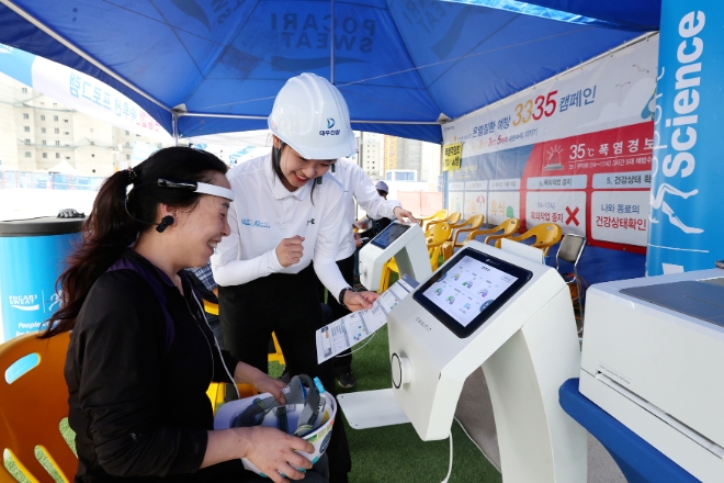 ‘온열질환 대처 솔루션’ 체험존에서 자가진단 검사를 하고 있는 대우건설 근로자 / 사진=대우건설 제공