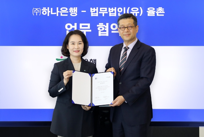 하나은행은 지난 27일 오후 서울시 삼성동에 위치한 법무법인(유) 율촌 본사에서 법무법인(유) 율촌과 청년 창업기업 육성 및 상시 지원체계 마련을 위한 업무협약을 체결했다고 밝혔다. 이날 협약식에 참석한 김소정 하나은행 디지털그룹장(사진 왼쪽)이 법무법인 율촌(유) IP&Tech 융합부문장 손도일 변호사와 함께 협약서를 들고 기념촬영을 하고 있다. / 사진=하나은행 제공