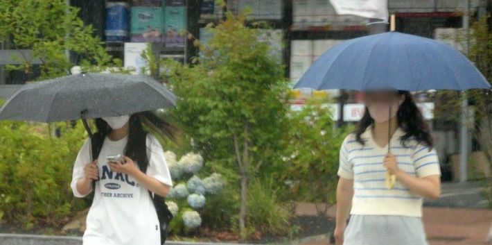 전국적으로 장맛비가 내리기 시작한 지난 26일 전북 전주시 백제대로에서 시민들이 우산으로 비를 피하며 길을 지나는 모습.