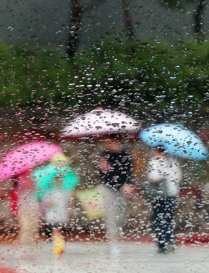 장맛비가 내리는 26일 부산 남구의 한 횡단보도에서 시민들이 우산을 쓴 채 발걸음을 재촉하고 있다.