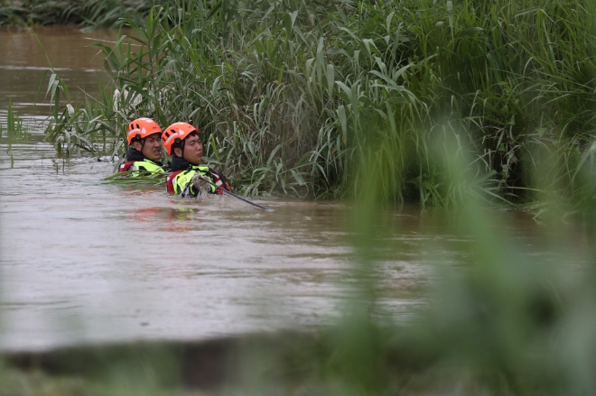 지난 28일 오후 전남 함평군 엄다면 하천에서 소방특수구조대원이 전날 밤 폭우 피해를 막으려다가 실종된 수리시설 감시원을 찾아 수중 수색을 하고 있다. / 연합뉴스