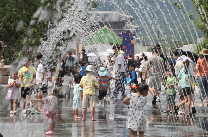 지난달 25일 서울 종로구 광화문 광장 분수대에서 어린이들이 물장난을 치며 더위를 식히는 모습.