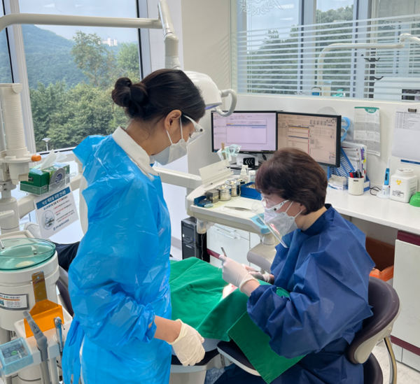 관악서울대치과병원치과보존과조낙연교수(오른쪽)가환자를진료하고있다.