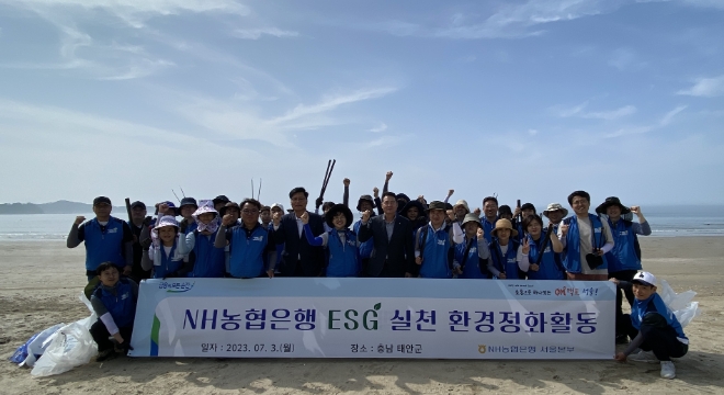 (첫줄 오른쪽 일곱번째부터 이경신 안면도농협 조합장, 조은주 NH농협은행 서울본부장, 서종덕 안면도농협 상임이사, 한성식 농협노조 서울지역위원장) NH농협은행 서울본부 직원들이 신두리해변에서 환경정화활동을 실시했다. / 사진=NH농협은행 제공