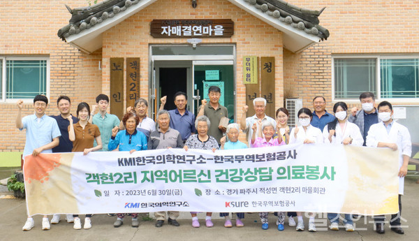 KMI한국의학연구소와한국무역보험공사직원들이지난달30일경기도파주시객현2리마을회관에서진행된지역어르신대상의료봉사에서기념촬영을하고있다