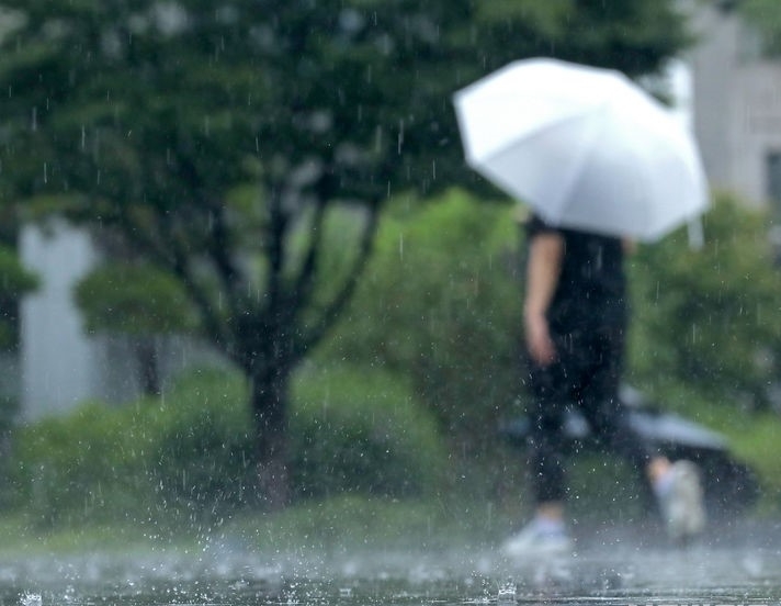 지난 4일 오후 서울 종로구 광화문광장에서 시민들이 우산을 쓰고 이동하는 모습.