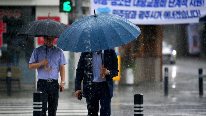 광주·전남에 장맛비가 내리는 4일 오전 광주 동구 구시청 주변 횡단보도에서 시민들이 우산을 쓴 채 길을 재촉하고 있다. 