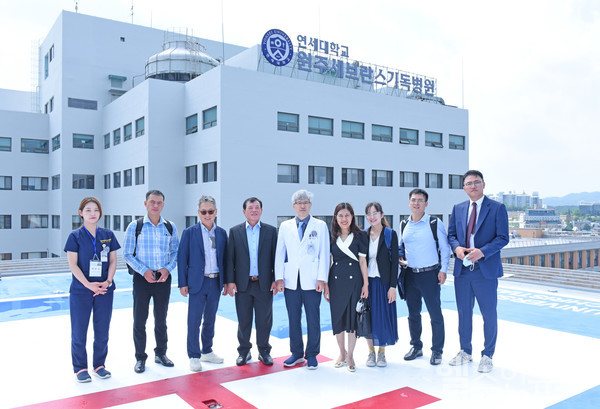 원주연세의료원김현교수(가운대)를비롯해업무협약에참여한이들이원주세브란스기독병원헬리패드에서단체기념촬영을하고있다.