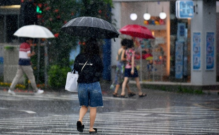 광주·전남에 장맛비가 내리는 4일 오전 광주 동구 구시청 주변 횡단보도에서 시민들이 우산을 쓴 채 길을 재촉하고 있다.