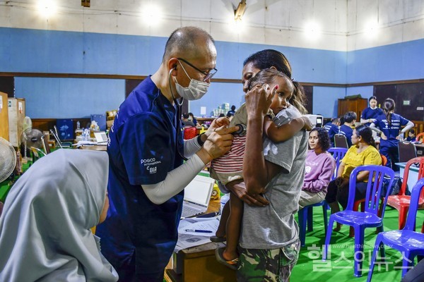 (왼쪽)고려대안산병원감염내과박대원교수가의료봉사중인도네시아아이를진찰하고있다